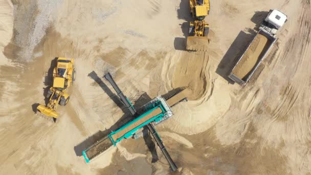 Aerial view loading bulldozer in open air quarry. Industria minera de arena. Máquina de la excavadora. Buldózer de orugas moviéndose en la mina de arena. Maquinaria minera que trabaja en cantera de arena. Drone vista de equipos mineros — Vídeos de Stock