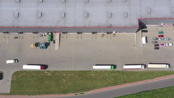 Klouzavý Vzdušný záběr průmyslového skladu nakládací plošiny, kde mnoho nákladních aut s návěsy naložením/vyloží zboží. Foťák 4k UHD. — Stock video