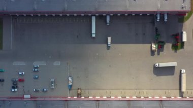 Malzeme deposunun havadan görüntüsü. Sanayi bölgesindeki lojistik merkezi yukarıdan. Lojistik merkezde yüklenen kamyonların hava görüntüsü