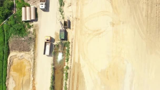 Camion-benne avec du sable va, en passant sur le côté de la construction de l'autoroute. Vue Aérienne — Video