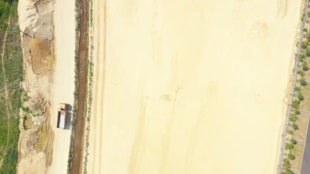 Dumper caminhão com areia está indo, passando sobre o lado da construção da estrada. Vista aérea — Vídeo de Stock