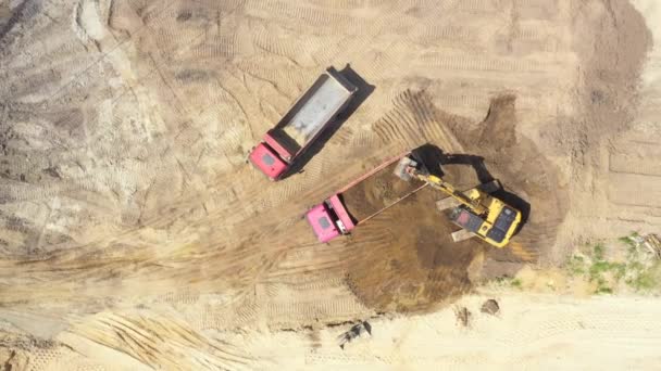 Blick von oben auf Bagger, der Sand in Kipper gießt. Bergbau — Stockvideo