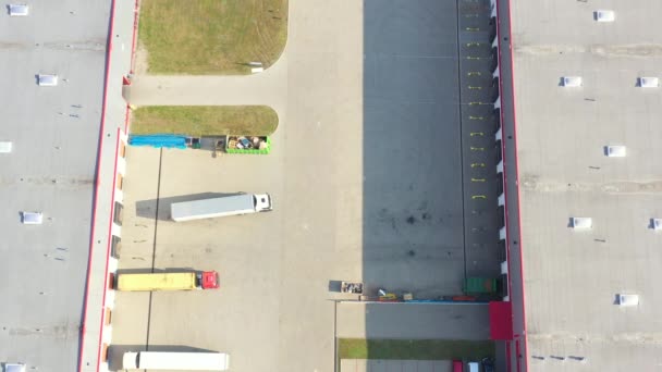 Vue aérienne de l'entrepôt de marchandises. Centre logistique dans la zone industrielle de la ville d'en haut. Vue aérienne du chargement des camions au centre logistique