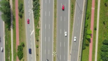Freay yolun üst görünümü. Klip. Ormanda trafiğe sahip otoyol. Araba ve kamyonlar ile banliyö otoyolu. Seyahat ve ulaşım. Havadan görünüm