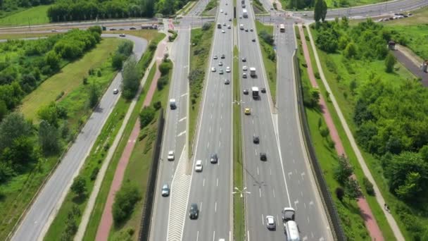 Vue du dessus de la route nationale. Clip. Autoroute avec circulation en forêt. Autoroute de banlieue avec voitures et camions. Voyage et transport. Vue aérienne 