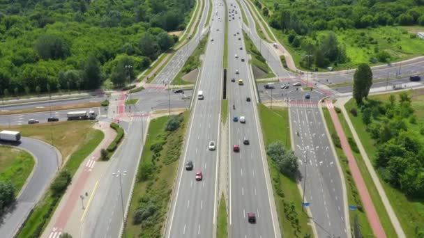 Vue du dessus de la route nationale. Clip. Autoroute avec circulation en forêt. Autoroute de banlieue avec voitures et camions. Voyage et transport. Vue aérienne 