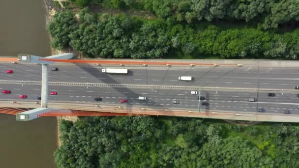 Міський автомобіль, що рухається на шосе мостом на фоні гладкої поверхні річки вид на дрон — стокове відео