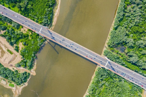 Городской автомобиль движется по мосту на фоне гладкой реки сюр — стоковое фото
