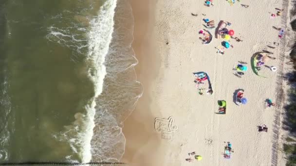 カラフルな傘を見せるビーチや、夏の日にリラックスした人々。バルト海。航空写真。ヘル — ストック動画