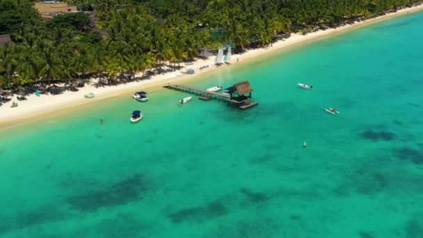 Deslízate por encima de un muelle soleado y un océano cristalino en Trou aux Biches, Mauricio — Vídeos de Stock