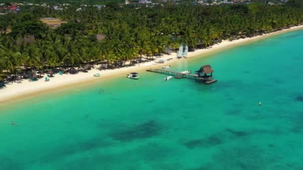 Deslízate por encima de un muelle soleado y un océano cristalino en Trou aux Biches, Mauricio — Vídeos de Stock