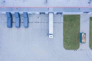 Logostik merkezde boşalan kamyonların hava görüntüsü. Sanayi bölgesindeki lojistik merkezi yukarıdan. Lojistik merkezde yüklenen kamyonların hava görüntüsü