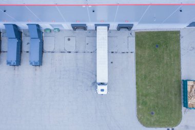 Malzeme deposunun havadan görüntüsü. Sanayi bölgesindeki lojistik merkezi yukarıdan. Lojistik merkezde yüklenen kamyonların hava görüntüsü