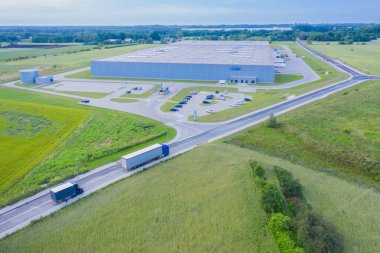Malzeme deposunun havadan görüntüsü. Sanayi bölgesindeki lojistik merkezi yukarıdan. Lojistik merkezde yüklenen kamyonların hava görüntüsü. İnsansız hava aracından görüntüle.