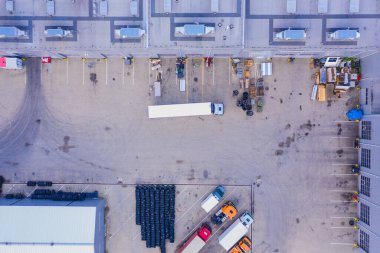 Malzeme deposunun havadan görüntüsü. Sanayi bölgesindeki lojistik merkezi yukarıdan. Lojistik merkezde yüklenen kamyonların hava görüntüsü