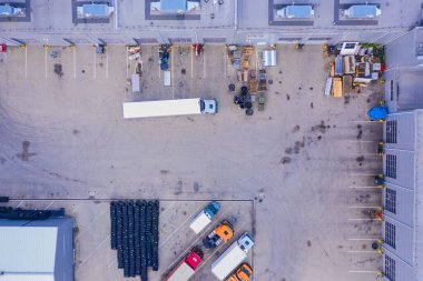 Malzeme deposunun havadan görüntüsü. Sanayi bölgesindeki lojistik merkezi yukarıdan. Lojistik merkezde yüklenen kamyonların hava görüntüsü