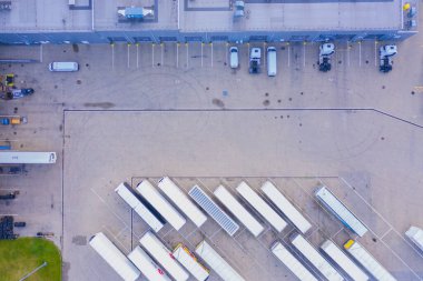 Malzeme deposunun havadan görüntüsü. Sanayi bölgesindeki lojistik merkezi yukarıdan. Lojistik merkezde yüklenen kamyonların hava görüntüsü