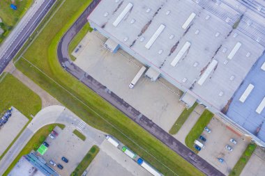 Malzeme deposunun havadan görüntüsü. Sanayi bölgesindeki lojistik merkezi yukarıdan. Lojistik merkezde yüklenen kamyonların hava görüntüsü