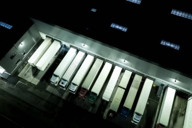 Gece Modern Lojistik Merkezi, beyaz minibüs ve karavan rampası. Hava Görünümü
