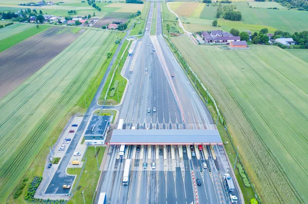 Car traffic transportation on multiple lanes highway road and toll collection gate, drone aerial top view. Commuter transport, city life concept.A2 Poland Lodz