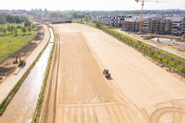 Kumlu yüzeydeki yol kenarındaki makinelerin ve mayın ekipmanlarının hava görüntüsü. Varşova Wilanow