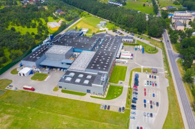 Çatıda güneş panelleri ve birçok kamyonla Endüstriyel Depolama Alanının Havadan Üst Görünümü.