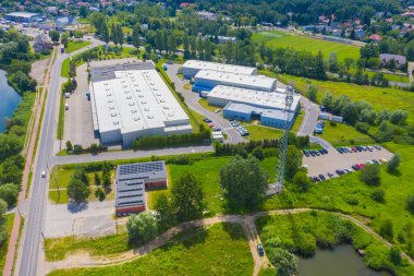 Çatıda güneş panelleri ve birçok kamyonla Endüstriyel Depolama Alanının Havadan Üst Görünümü.