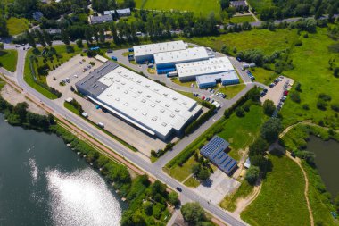 Kamyonlarda ve lojistik merkezde hava aracı. Depo anteninden. Modern lojistik merkezi, beyaz minibüs ve karavan rampası. 