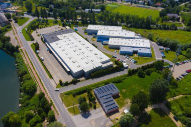 Kamyonlarda ve lojistik merkezde hava aracı. Depo anteninden. Modern lojistik merkezi, beyaz minibüs ve karavan rampası. 