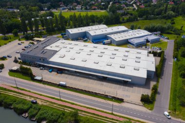 Malzeme deposunun havadan görüntüsü. Sanayi bölgesindeki lojistik merkezi yukarıdan. Lojistik merkezde yüklenen kamyonların hava görüntüsü. İnsansız hava aracından görüntüle