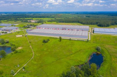 Malzeme deposunun havadan görüntüsü. Sanayi bölgesindeki lojistik merkezi yukarıdan. Lojistik merkezde yüklenen kamyonların hava görüntüsü. İnsansız hava aracından görüntüle