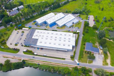 Malzeme deposunun havadan görüntüsü. Sanayi bölgesindeki lojistik merkezi yukarıdan. Lojistik merkezde yüklenen kamyonların hava görüntüsü. İnsansız hava aracından görüntüle