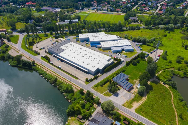 Aerial drone on trucks and logistic center. Warehouse aerial. Modern logistics center, white van and trailers standingon ramp.