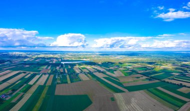 Kırsal kesimin kalbinde sıcak akşam güneşiyle aydınlatılan, oldukça ağaçlık sınırları olan, cennet gibi yuvarlanan tarım arazilerinin panoramik hava manzarası.