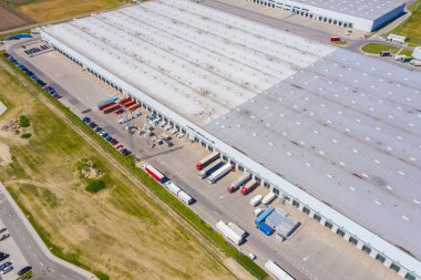 Malzeme deposunun havadan görüntüsü. Sanayi bölgesindeki lojistik merkezi yukarıdan. Lojistik merkez stok fotoğrafına yüklenen kamyonların hava görüntüsü