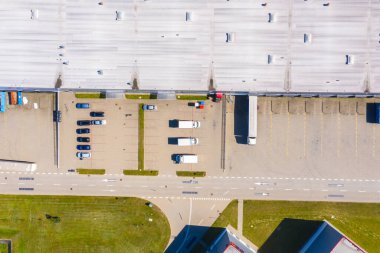Malzeme deposunun havadan görüntüsü. Sanayi bölgesindeki lojistik merkezi yukarıdan. Lojistik merkezde yüklenen kamyonların hava görüntüsü
