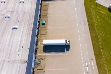 Malzeme deposunun havadan görüntüsü. Sanayi bölgesindeki lojistik merkezi yukarıdan. Lojistik merkezde yüklenen kamyonların hava görüntüsü
