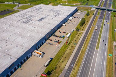 Depolu büyük lojistik parkının havadan görüntüsü. Merkez, birçok yarı karavan kamyonu yüklüyor..