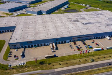 Depolu büyük lojistik parkının havadan görüntüsü. Merkez, birçok yarı karavan kamyonu yüklüyor..