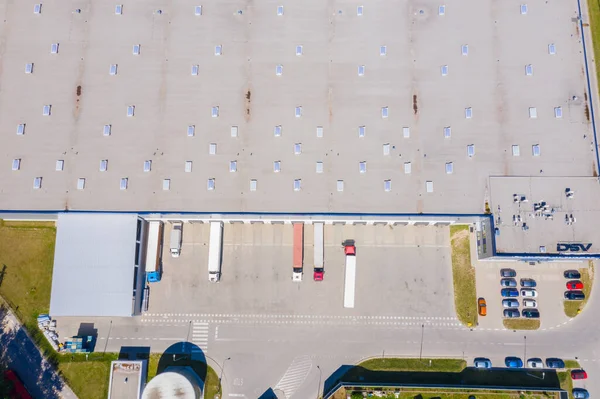 Aerial Shot of Industrial Warehouse Loading Dock where Many Truck with Semi Trailers Load Merchandise.