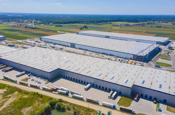 Aerial Shot of Industrial Warehouse Loading Dock where Many Truck with Semi Trailers Load Merchandise.