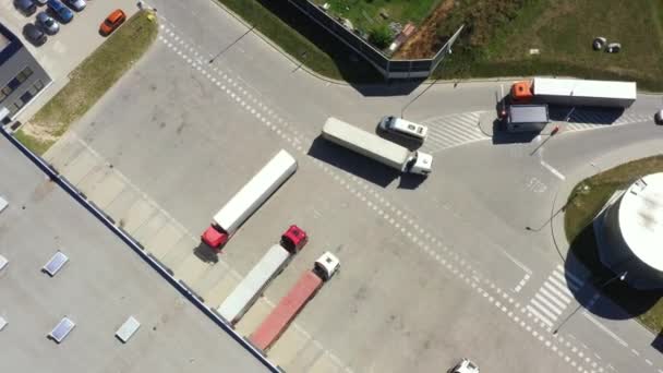 Luftaufnahme einer Verladestation für Industrielager, auf der viele LKW mit Sattelaufliegern Waren beladen. — Stockvideo