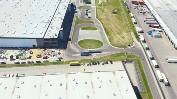 Tiro aéreo del muelle de carga industrial del almacén donde muchos camiones con semirremolques cargan mercancías. — Vídeos de Stock