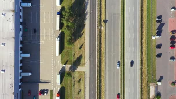 Vista aérea do armazém de mercadorias. Centro de logística na zona industrial da cidade de cima. Vista aérea do carregamento de caminhões no centro logístico. Vista de drone. — Vídeo de Stock