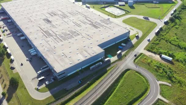 Vista aerea del magazzino merci. Centro logistico nella zona industriale della città dall'alto. Vista aerea di camion che caricano presso il centro logistico. Vista dal drone. — Video Stock