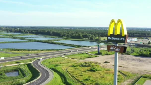 En flygbild av McDonalds gyllene valv. Nära motorvägen — Stockvideo