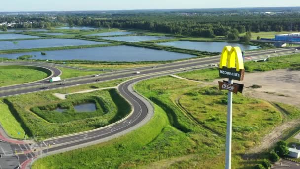 En flygbild av McDonalds gyllene valv. Nära motorvägen — Stockvideo