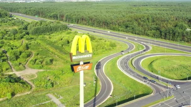 Una toma aérea de los Arcos Dorados de McDonalds. Cerca de la autopista — Vídeo de stock