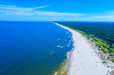 Baltık Denizi 'nde saydam turkuaz deniz manzarası. Deniz manzarası, plaj, güzel dalgalar, gün batımında mavi su. İHA 'dan üst görünüm