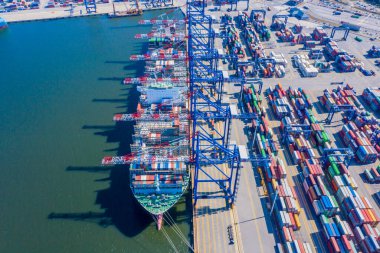 Limanda vinç yüklü konteynır gemisi, konteynır taşıyan konteynır ithalat ve ihracat işi lojistik ve ulaşım, hava üst görünümü.